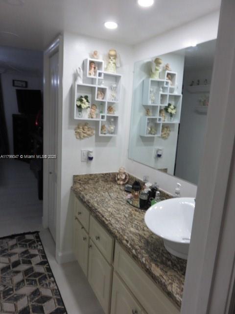 7040 Southwest 24th Street, Unit 104 Miami, FL 33155 - Photo 20 of 27 a bathroom with a granite countertop sink and a mirror