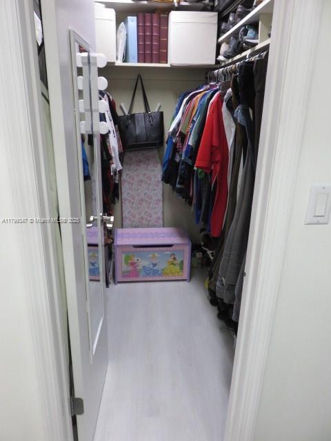 7040 Southwest 24th Street, Unit 104 Miami, FL 33155 - Photo 23 of 27 a view of walk in closet with clothes and shoes