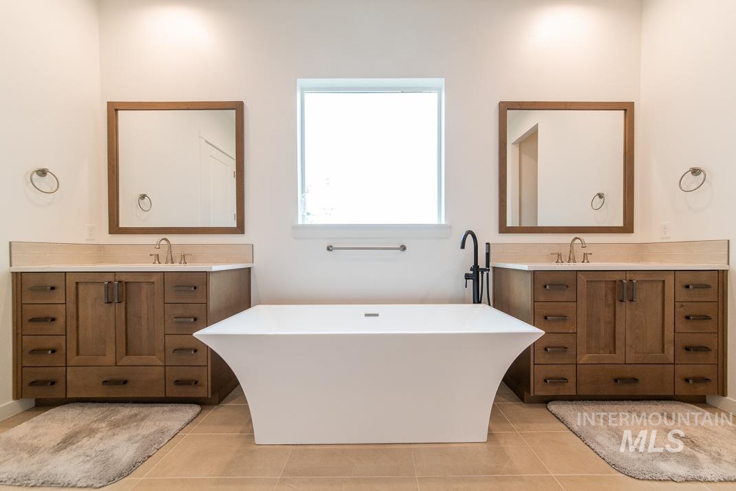 5610 Sparky Avenue Caldwell, ID 83607 - Photo 13 of 27 Full bath featuring two vanities, a soaking tub, and light tile patterned floors