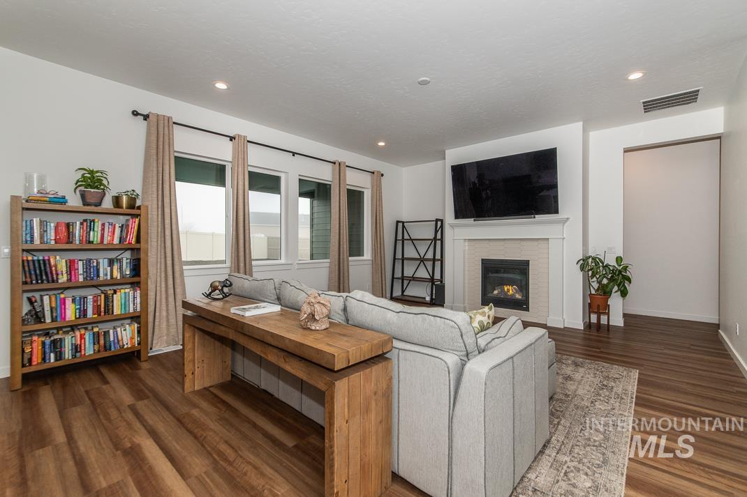 5610 Sparky Avenue Caldwell, ID 83607 - Photo 4 of 27 Living area featuring a glass covered fireplace, dark wood-type flooring, and recessed lighting