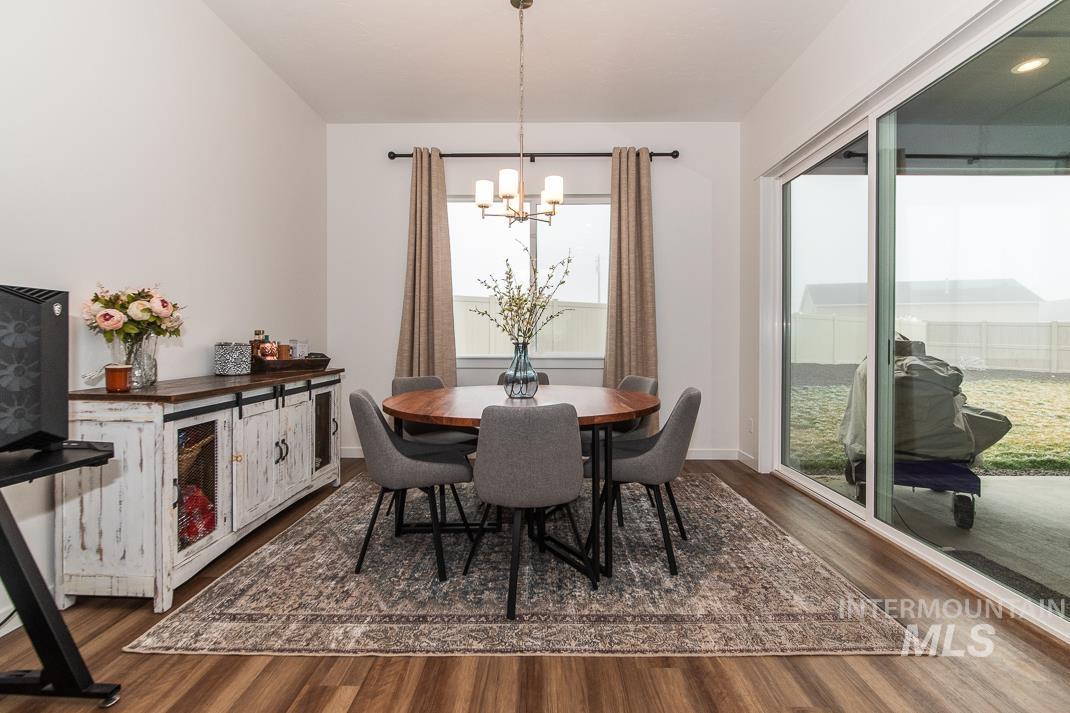 5610 Sparky Avenue Caldwell, ID 83607 - Photo 9 of 27 Dining area with dark wood-style floors and a chandelier