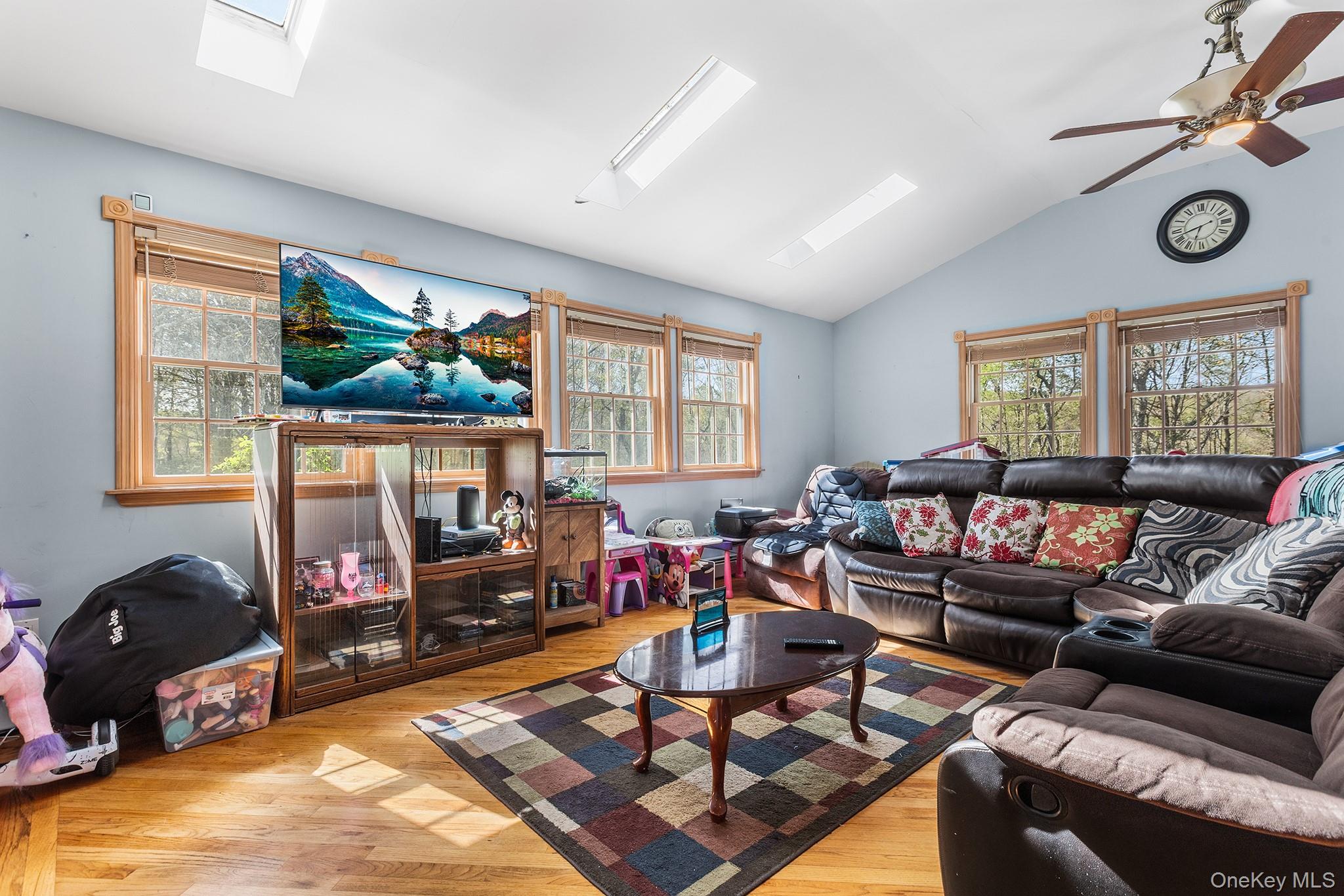 43 Taylor Road Parksville, NY 12768 - Photo 11 of 29 Vaulted ceiling living space featuring hardwood flooring and multiple windows with natural wood trim