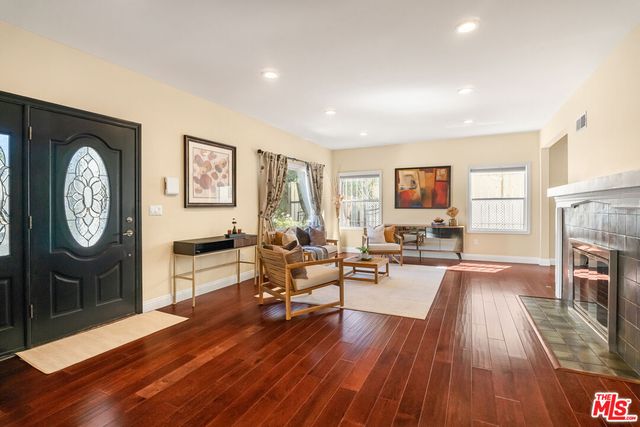 a large white kitchen with a large window and stainless steel appliances