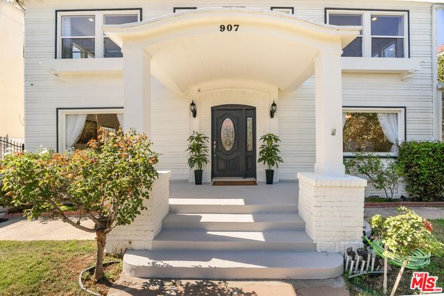 a living room with furniture fireplace and kitchen view