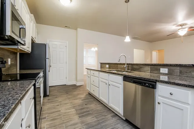 a kitchen with stainless steel appliances granite countertop a sink and stove top oven