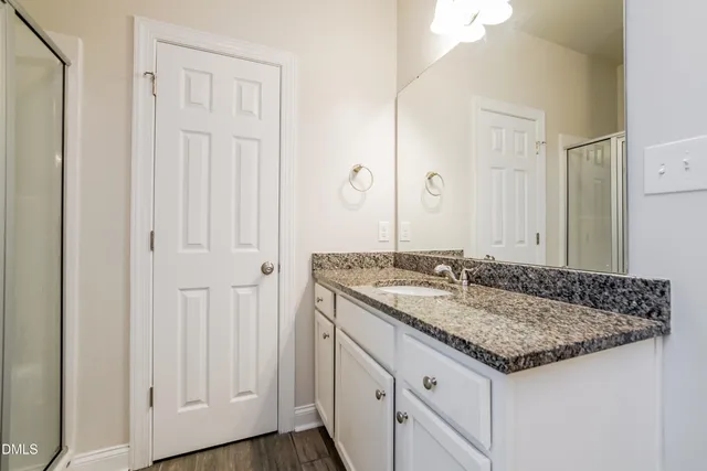 a bathroom with a granite countertop sink and a mirror