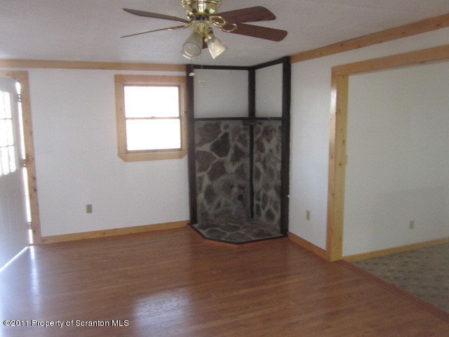 2179 Hunsinger Road Hallstead, PA 18822 - Photo 4 of 10 an empty room with wooden floor fan and windows
