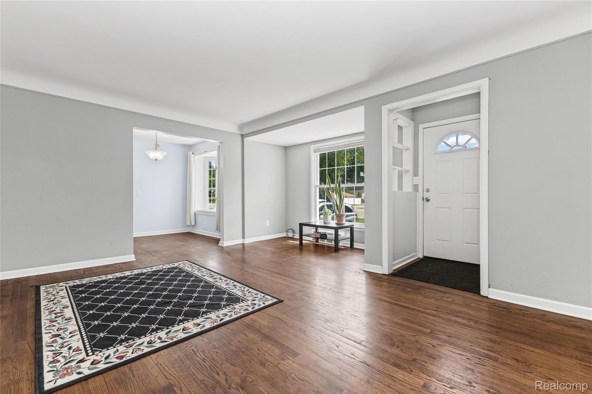 26508 Five Mile Road Redford, MI 48239 - Photo 8 of 41 Wood-finish flooring throughout, featuring a distinct entryway with a multi-pane glass door, and a dedicated dining space with a ceiling-mounted light fixture