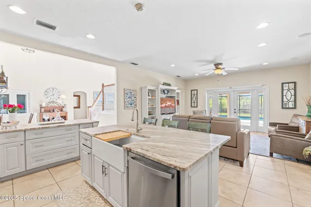 a kitchen with granite countertop a sink and white cabinets