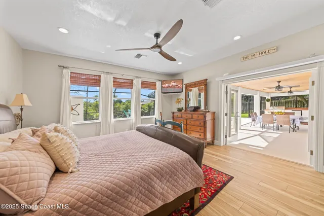 a spacious bedroom with a large bed and a large window with wooden floor