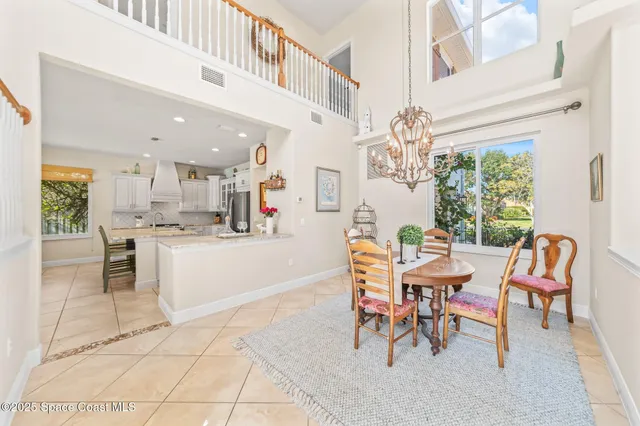 a dining hall with stainless steel appliances kitchen island granite countertop a table and chairs in it