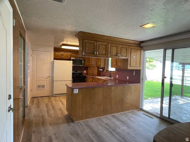 438 East Main Street Elsinore, UT 84724 - Photo 17 of 43 Kitchen featuring wood cabinetry, a breakfast bar, and sliding doors to covered patio.