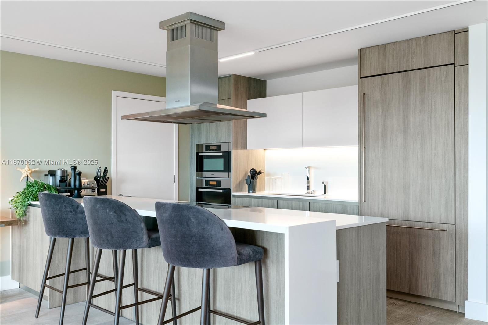 360 Ocean Drive, Unit 305S Key Biscayne, FL 33149 - Photo 13 of 27 a kitchen with stainless steel appliances a table and chairs in it