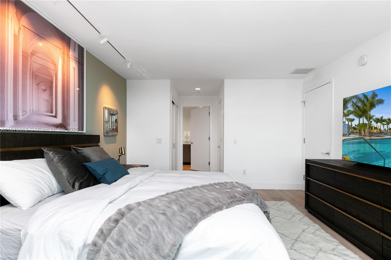 360 Ocean Drive, Unit 305S Key Biscayne, FL 33149 - Photo 19 of 27 a bedroom with a bed and a flat tv screen on dresser