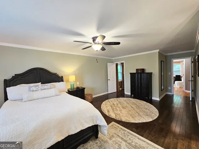 a bedroom with a large bed and wooden floor