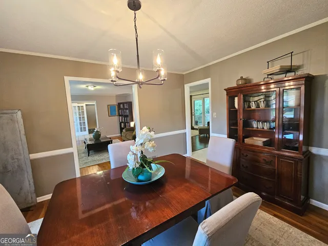 a dining room with furniture a chandelier and wooden floor