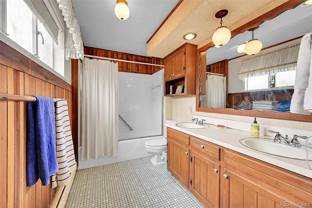 a spacious bathroom with a sink a toilet and a mirror