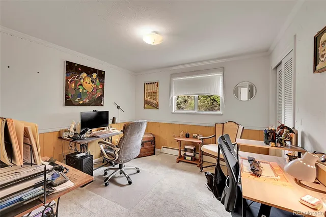 a view of a workspace with furniture and a window