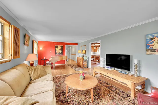 a living room with furniture a flat screen tv and a floor to ceiling window
