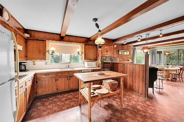a open kitchen with stainless steel appliances granite countertop a stove top oven a sink and white cabinets