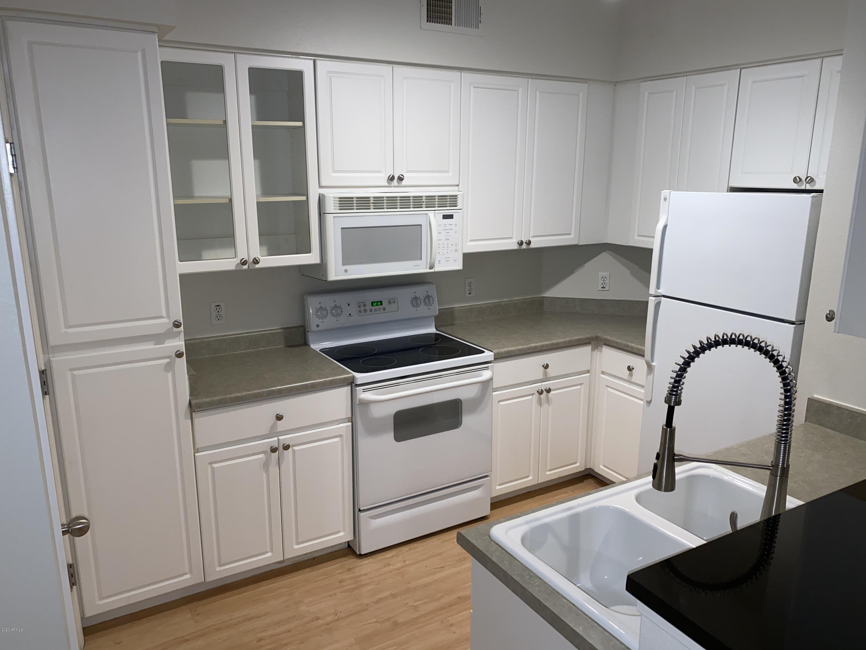 1701 East Colter Street, Unit 263 Phoenix, AZ 85016 - Photo 2 of 18 a kitchen with stainless steel appliances granite countertop a stove a sink and a microwave