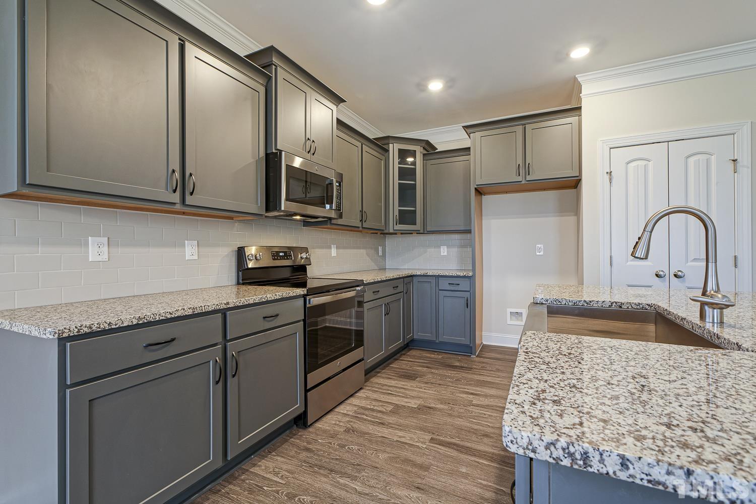 435 Cliffview Drive Garner, NC 27529 - Photo 14 of 45 a kitchen with stainless steel appliances granite countertop a sink stove and refrigerator