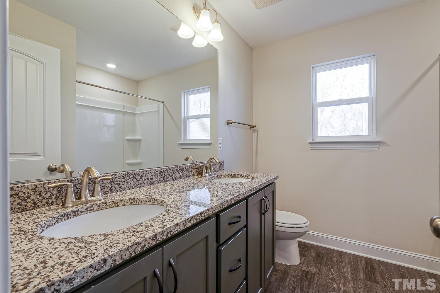435 Cliffview Drive Garner, NC 27529 - Photo 29 of 45 a bathroom with a granite countertop sink a toilet and a mirror