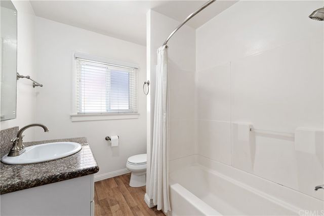 a bathroom with a granite countertop sink toilet and a bathtub