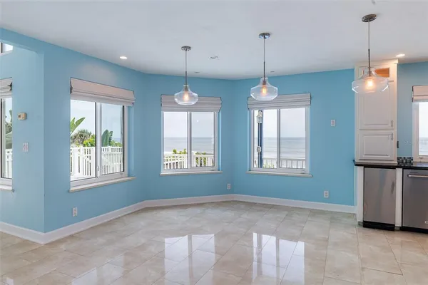 an empty room with windows and fireplace