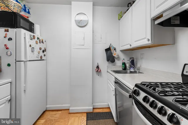 a kitchen with white cabinets and white appliances