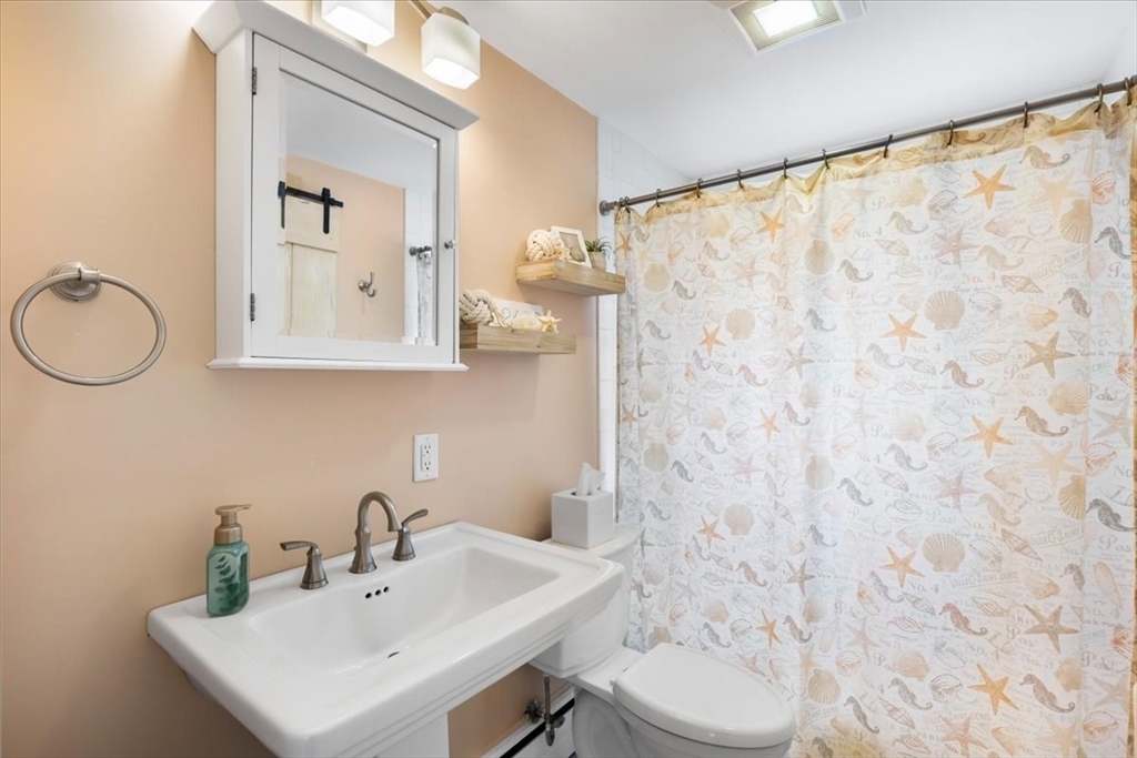 10 Earnshaw Street Boston, MA 02132 - Photo 17 of 35 a bathroom with a sink a toilet and a mirror