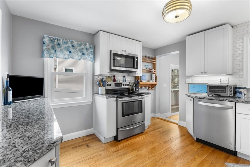 10 Earnshaw Street Boston, MA 02132 - Photo 7 of 35 a kitchen with stainless steel appliances granite countertop a stove a refrigerator and a microwave oven