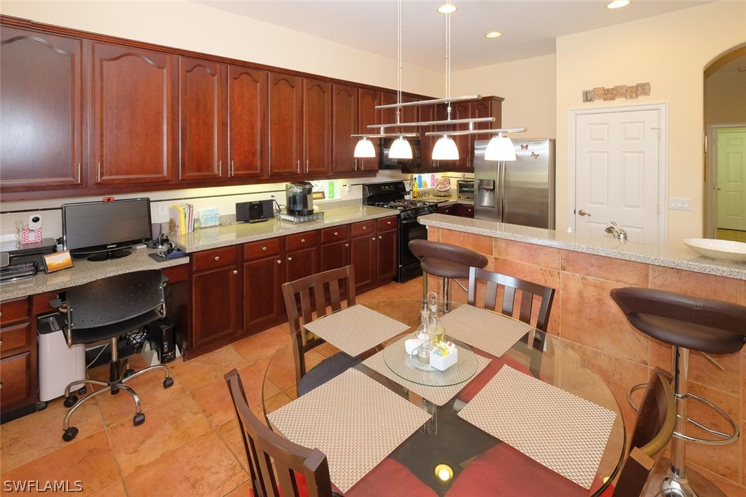 12882 Timber Ridge Drive Fort Myers, FL 33913 - Photo 10 of 25 a kitchen with a table chairs and a refrigerator