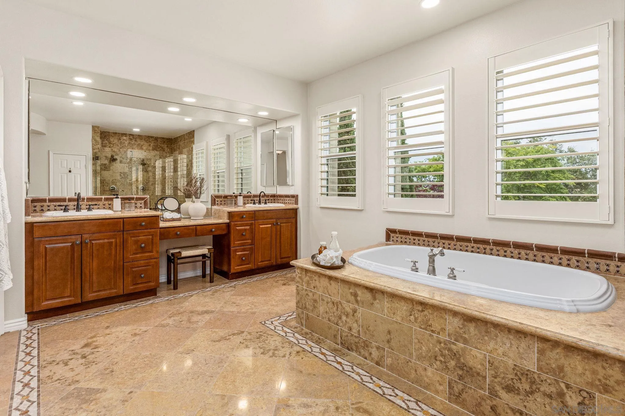 5582 Valerio Trail San Diego, CA 92130 - Photo 27 of 43 a spacious bathroom with a tub a sink a mirror and a shower
