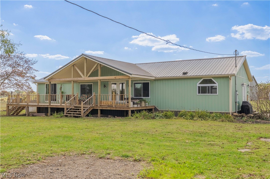 5267 Apollo Road Northeast Salineville, OH 43945 - Photo 2 of 33 Front view of house featuring a yard, stairs, a metal roof, and covered porch