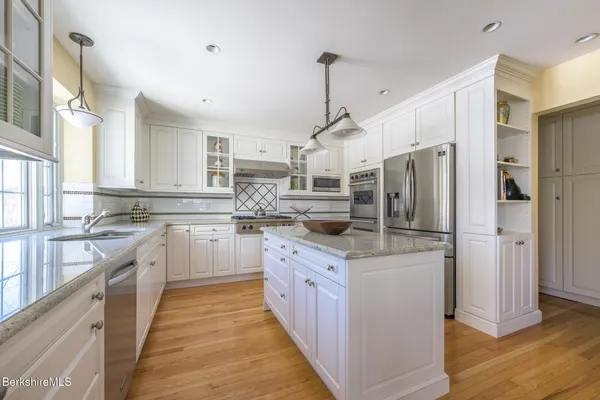 a kitchen with stainless steel appliances a stove a refrigerator and a sink