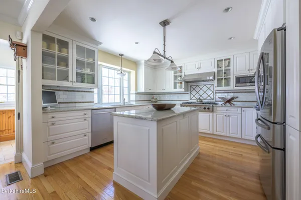 a kitchen with stainless steel appliances granite countertop a stove refrigerator and cabinets