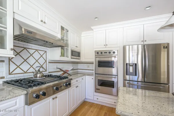 a kitchen with stainless steel appliances granite countertop a sink and cabinets