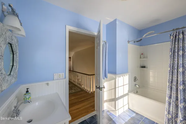 a view of a hallway with wooden floor and windows