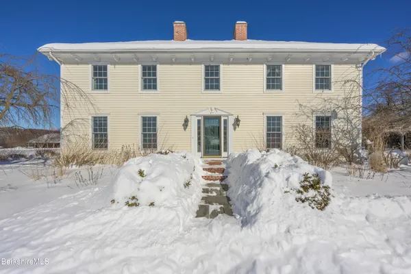 a kitchen with stainless steel appliances granite countertop a refrigerator a sink dishwasher a stove and white cabinets with wooden floor