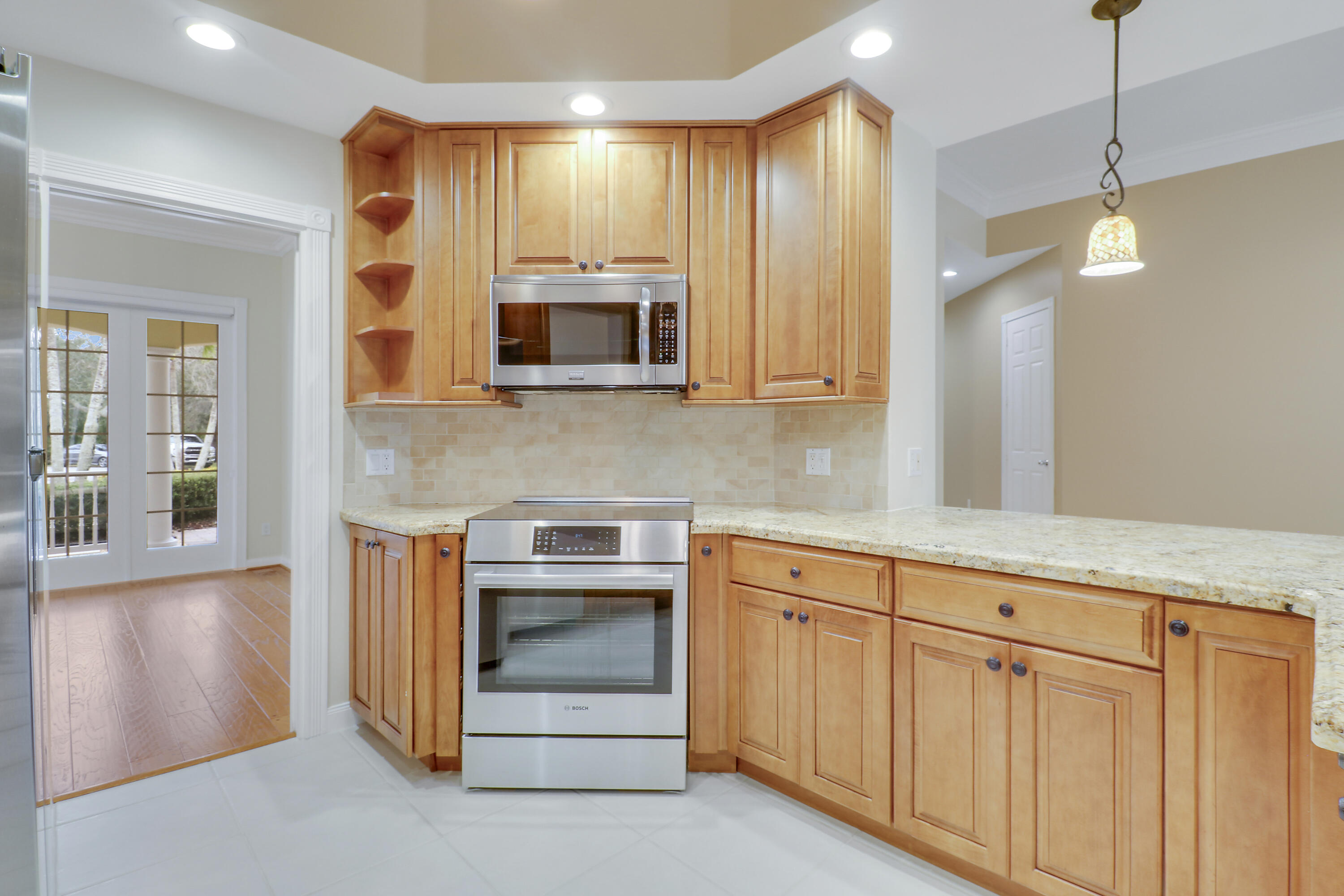 8657 Southeast Nicolete Lane Hobe Sound, FL 33455 - Photo 14 of 50 a kitchen with white cabinets and stainless steel appliances
