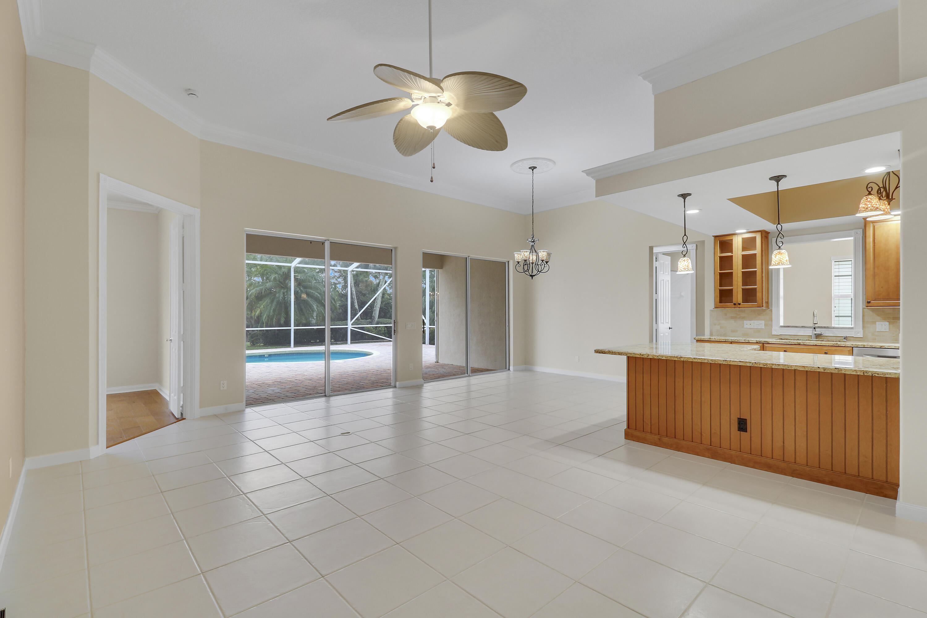 8657 Southeast Nicolete Lane Hobe Sound, FL 33455 - Photo 21 of 50 a large room with chandelier fan and windows
