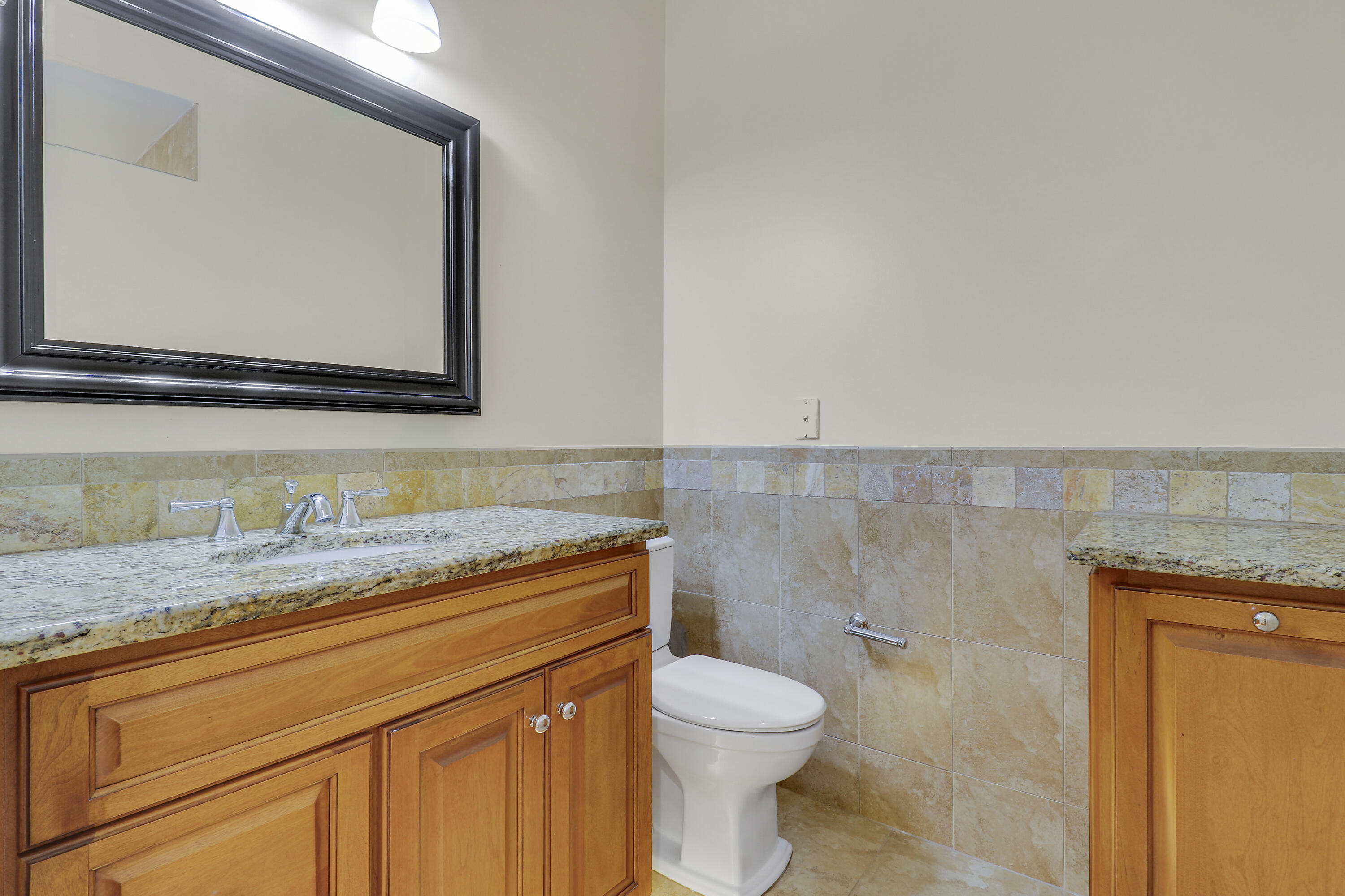 8657 Southeast Nicolete Lane Hobe Sound, FL 33455 - Photo 27 of 50 a bathroom with a granite countertop toilet sink and mirror
