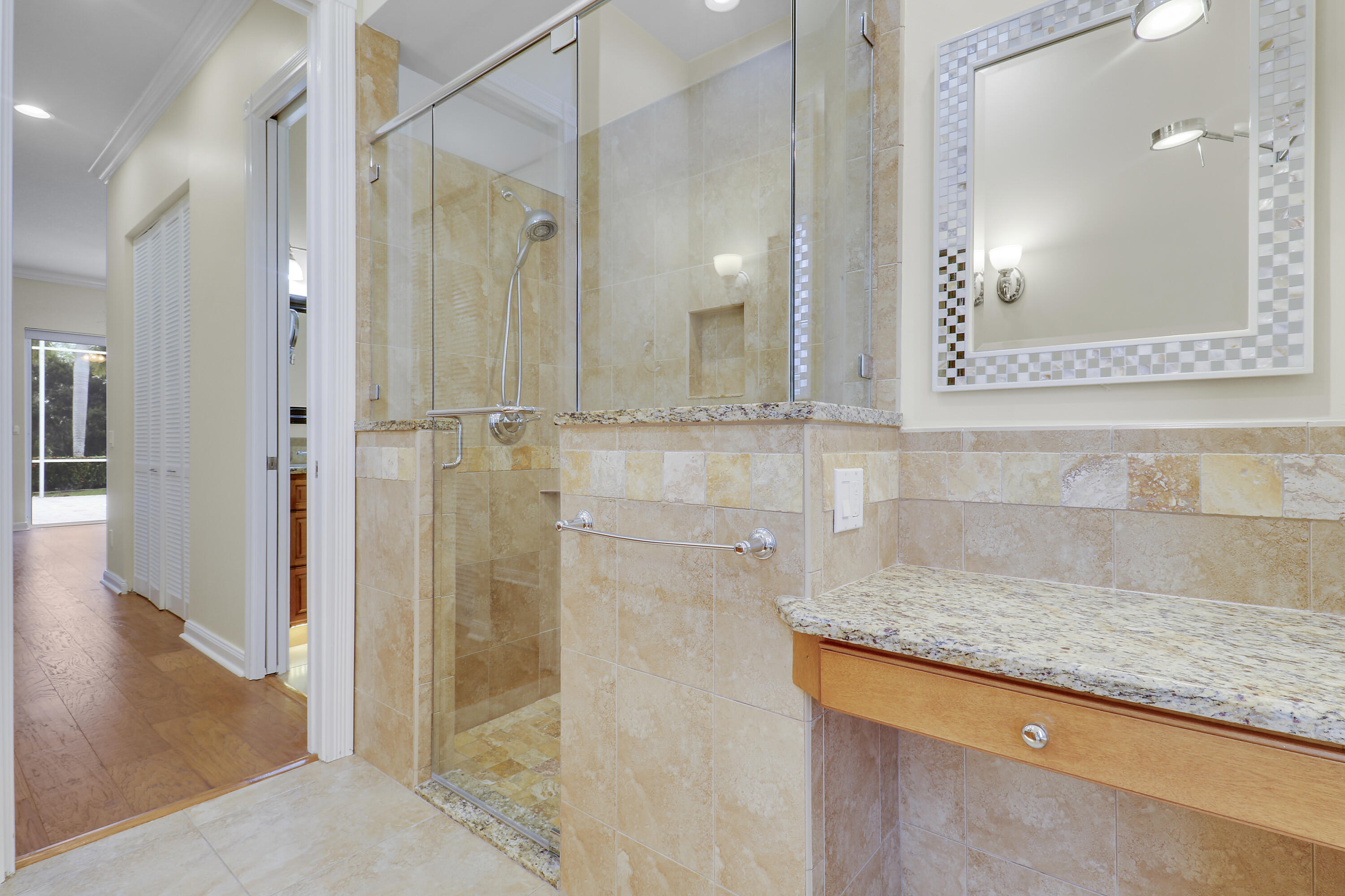 8657 Southeast Nicolete Lane Hobe Sound, FL 33455 - Photo 29 of 50 a bathroom with a granite countertop sink mirror and shower