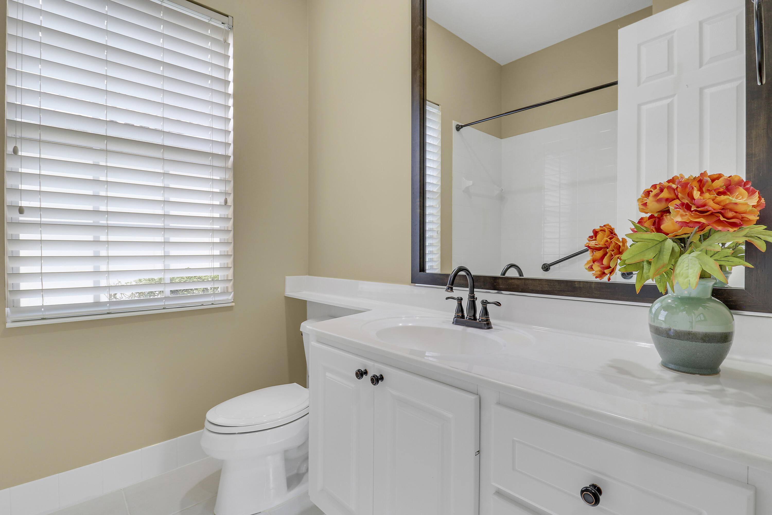 8657 Southeast Nicolete Lane Hobe Sound, FL 33455 - Photo 35 of 50 a bathroom with a sink a toilet and a mirror