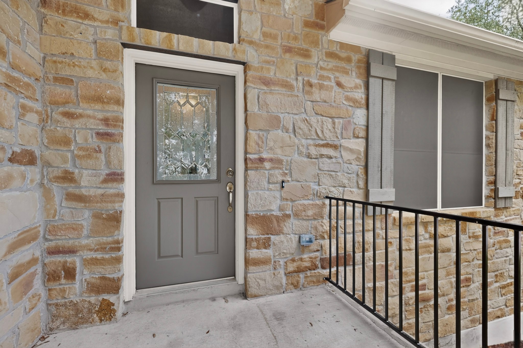 178 Limestone Trail Austin, TX 78737 - Photo 4 of 40 Stone veneer exterior featuring a gray entry door with decorative glass insert