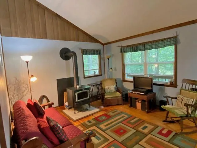 a living room with furniture a flat screen tv and a floor to ceiling window