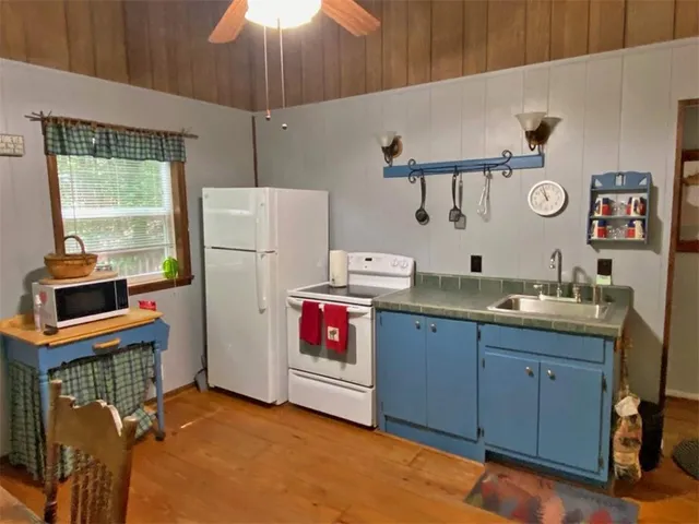 a kitchen with a refrigerator and a stove top oven