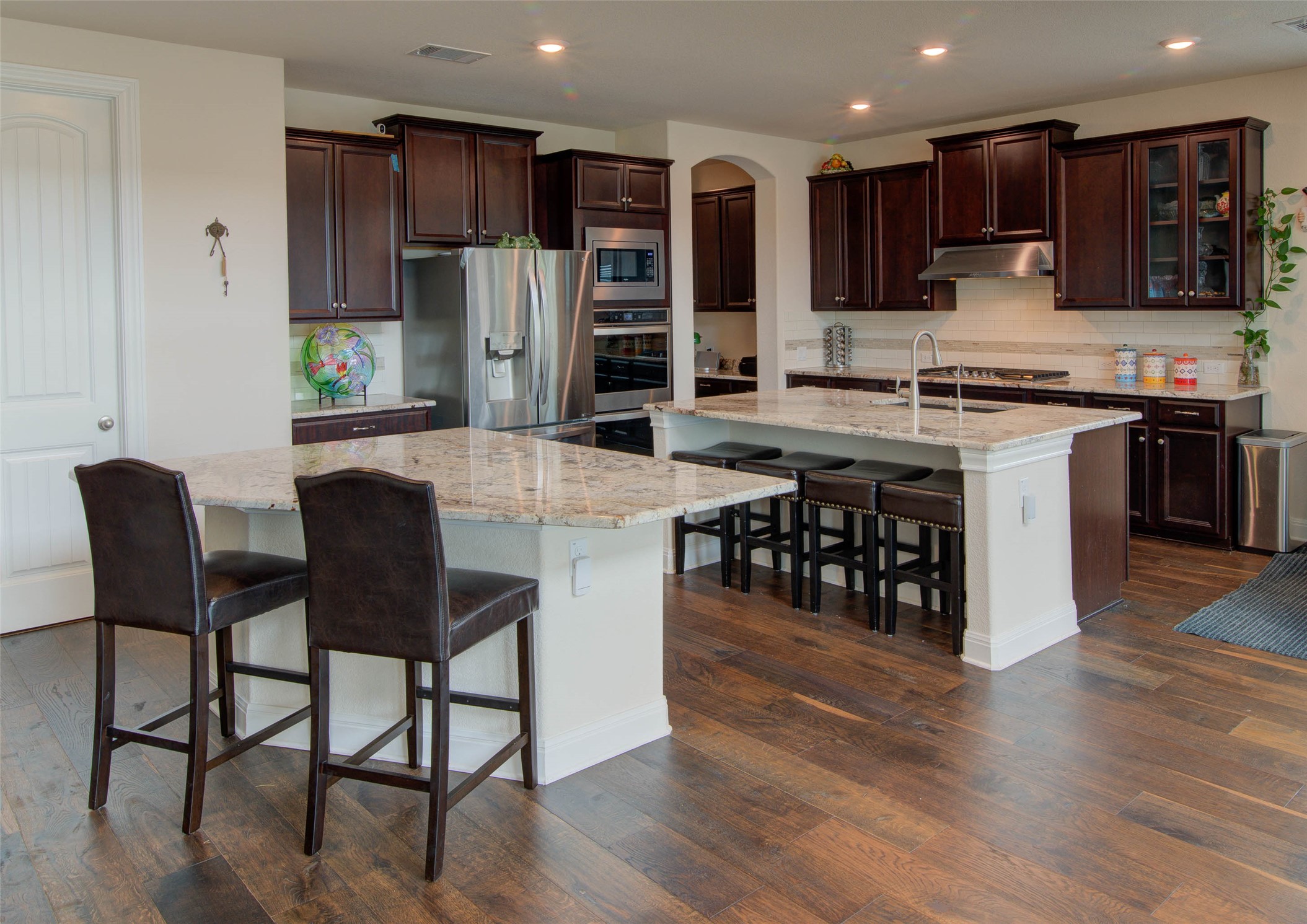 15621 Cabrillo Way Austin, TX 78738 - Photo 5 of 21 a kitchen with stainless steel appliances kitchen island granite countertop a table chairs and a refrigerator
