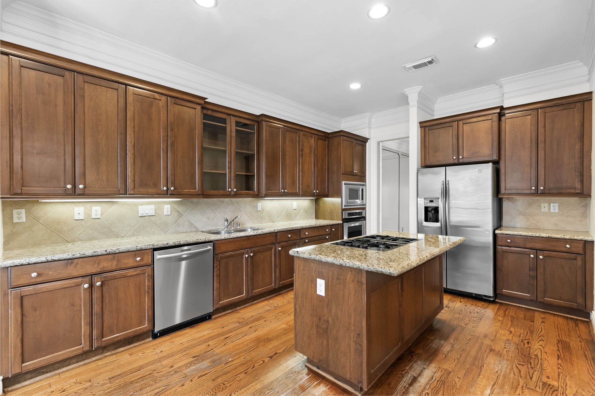 4026 Gramercy Street Houston, TX 77025 - Photo 9 of 35 a kitchen with stainless steel appliances granite countertop wooden cabinets a sink dishwasher and a stove top oven